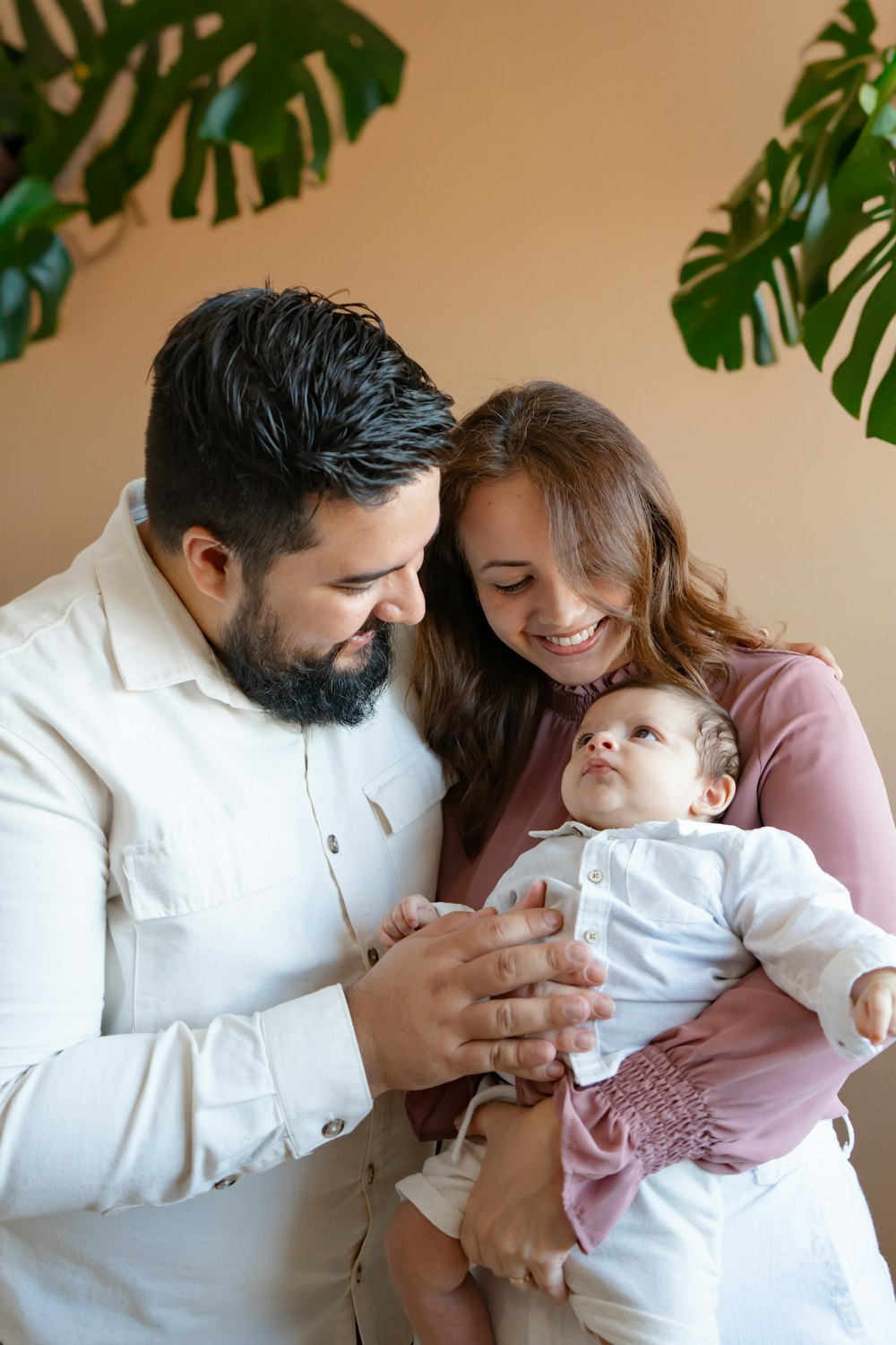 a man and woman holding a baby in their arms