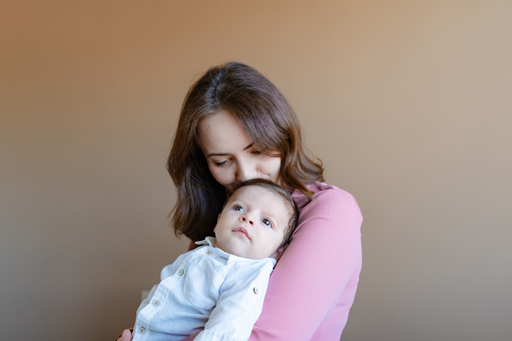 a woman holding a baby in her arms