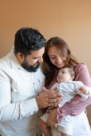 a man and woman holding a baby in their arms
