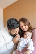a man and woman holding a baby in their arms