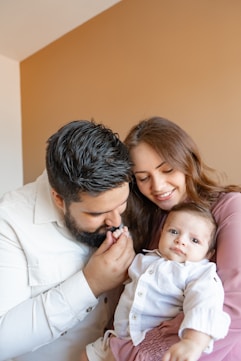 a man and woman holding a baby in their arms