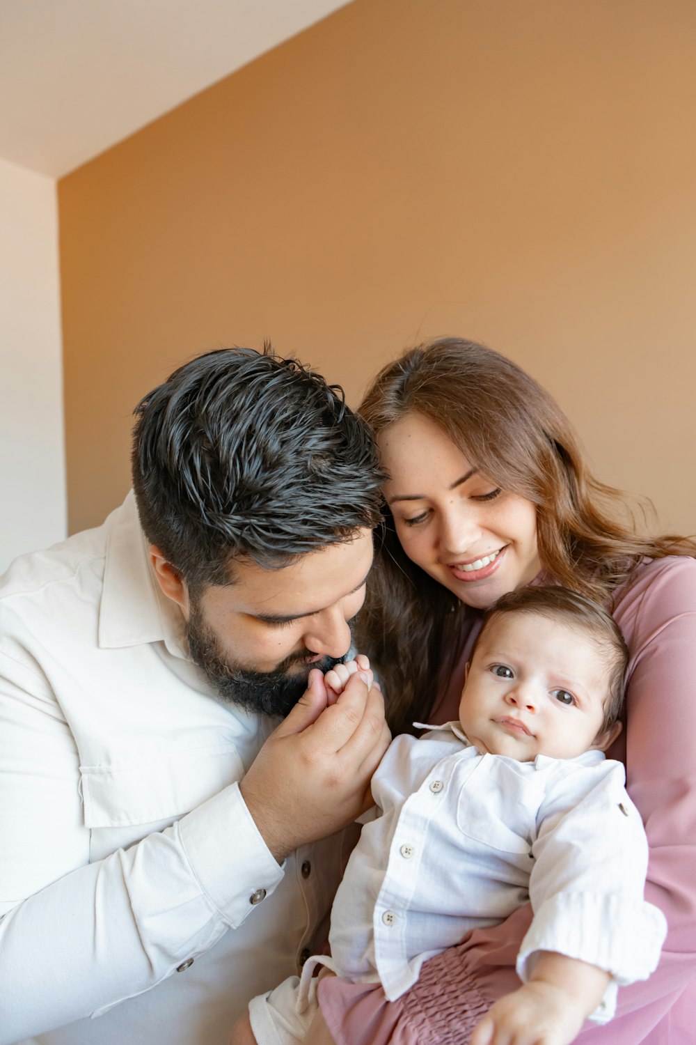 a man and woman holding a baby in their arms