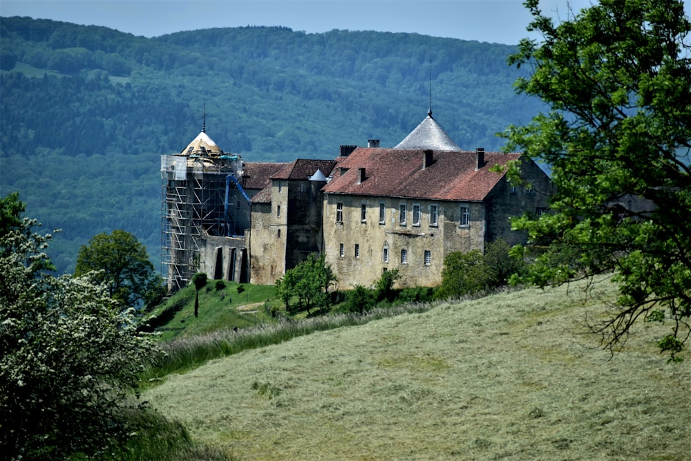 a large building sitting on top of a lush green hillside