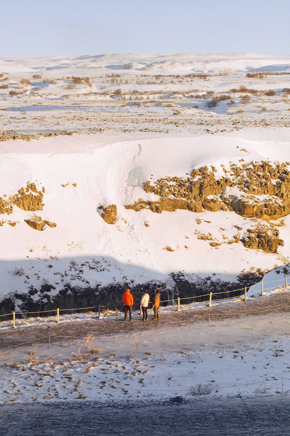 um grupo de pessoas caminhando por um campo coberto de neve