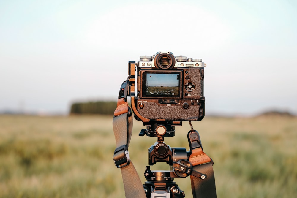 a camera attached to a tripod in a field