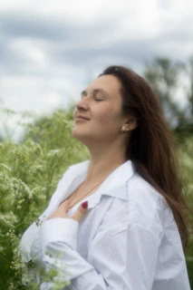 a woman standing in a field of tall grass
