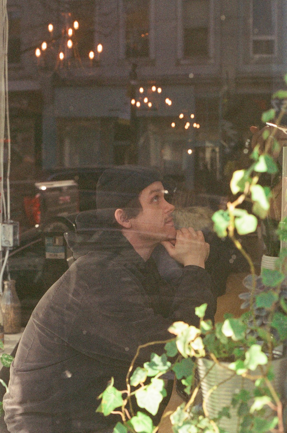 a man sitting in front of a window eating a donut