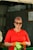 a woman in a red shirt is holding a green origami