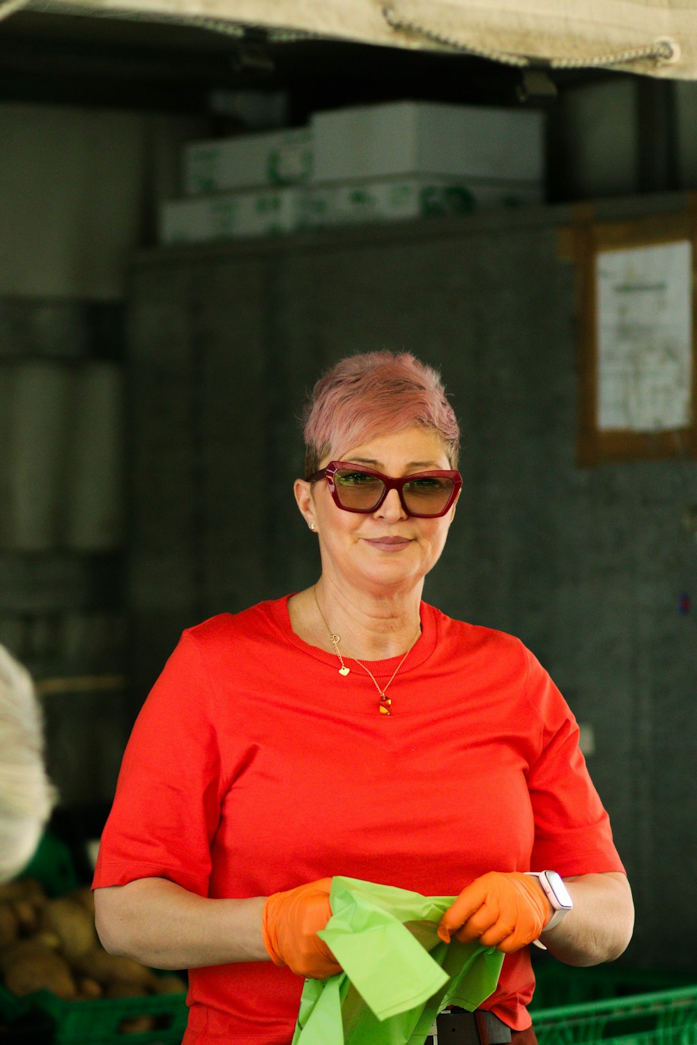 a woman in a red shirt is holding a green origami