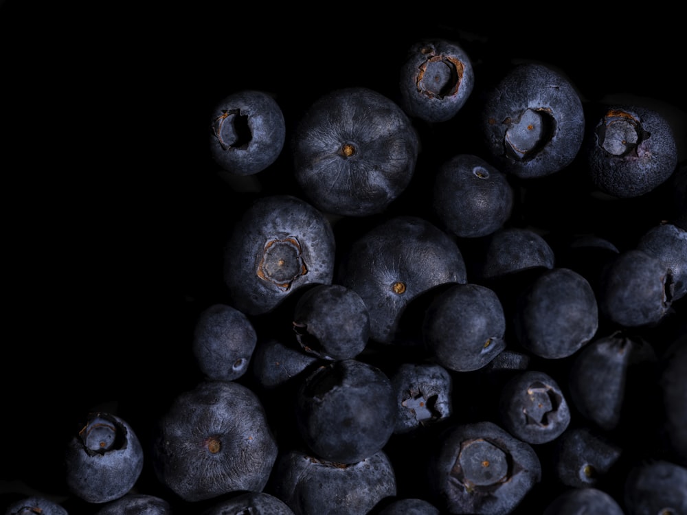 a pile of blueberries on a black background