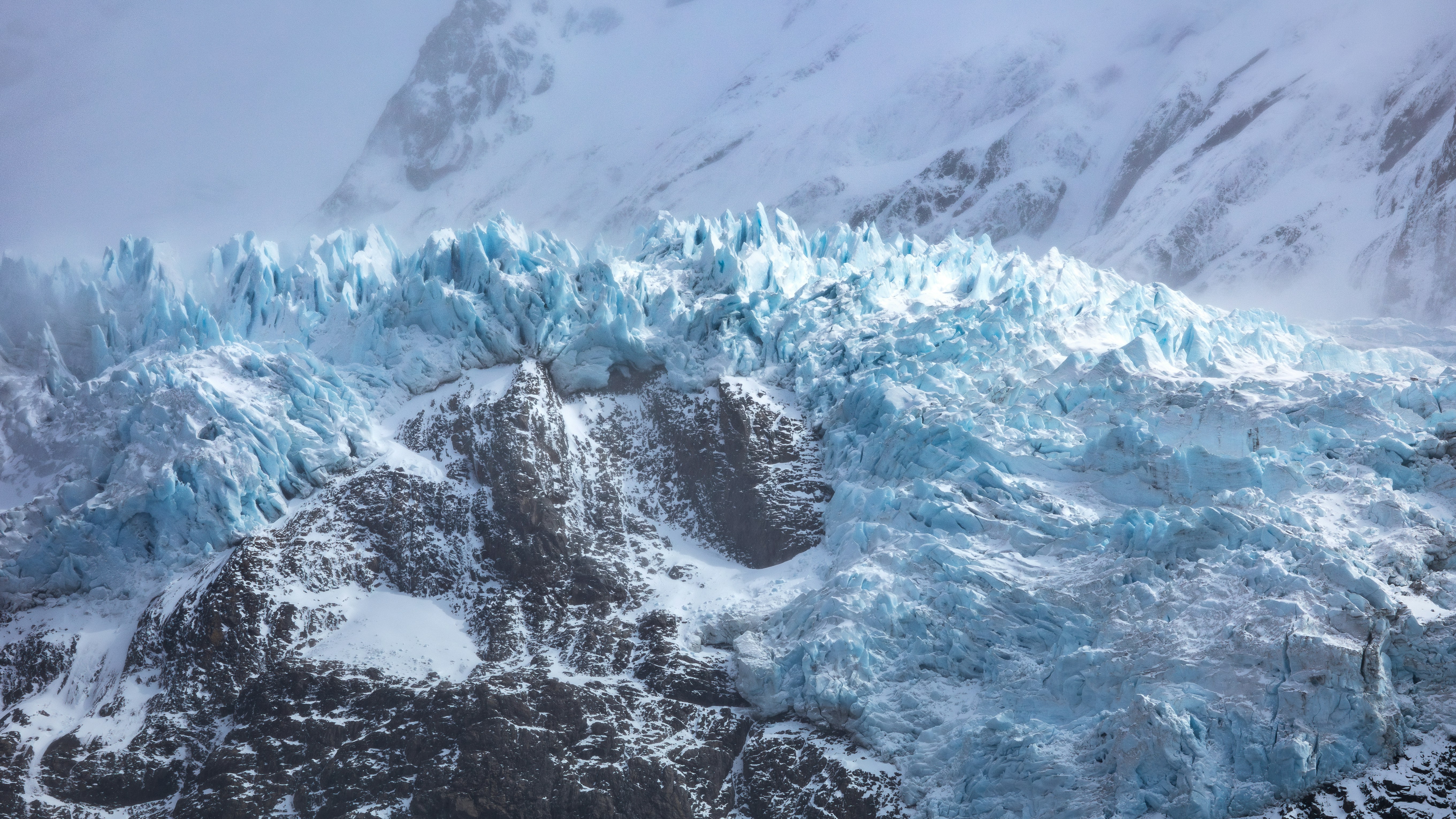"Frozen" Glaciar Piedras Blancas. The windy and cloudy day concealed this glacier behind a veil of mist. Only occasionally did rays of sunlight break through, illuminating patches of the blue ice.