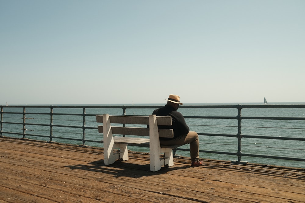 a person sitting on a bench on a pier