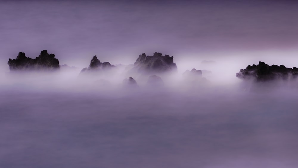 a group of rocks in the middle of a body of water