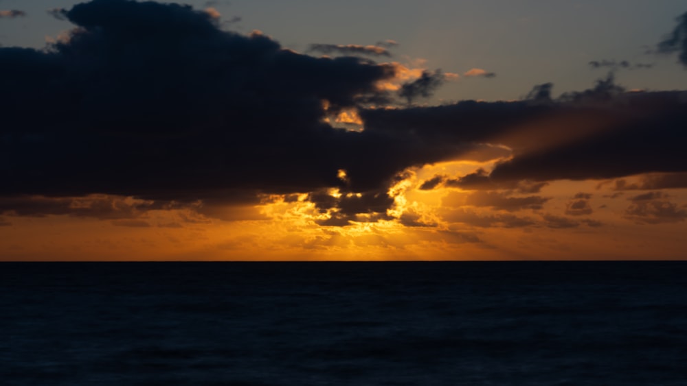 the sun is shining through the clouds over the ocean