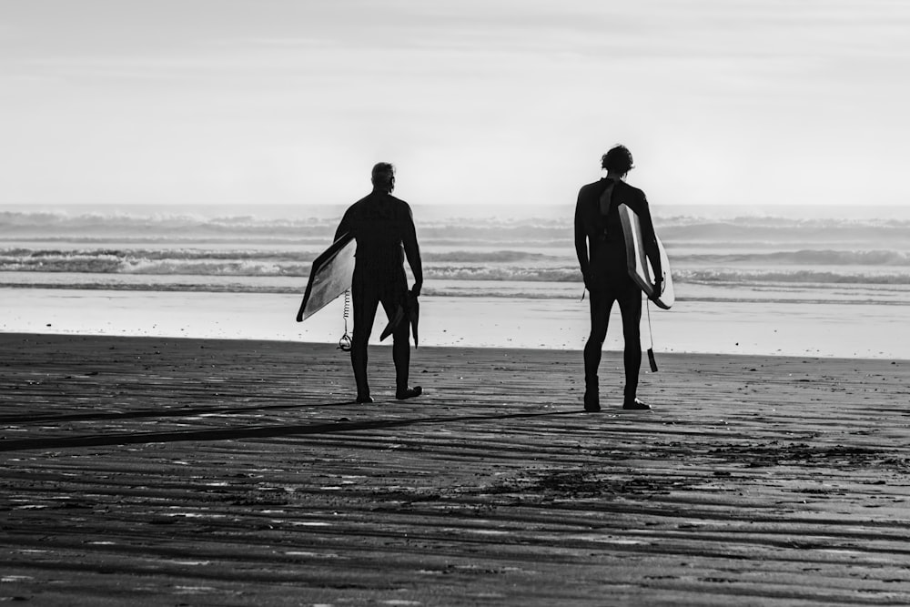 Un par de hombres parados en la cima de una playa