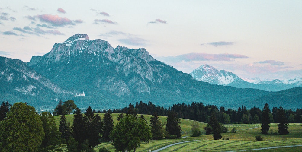 a scenic view of a mountain range with a winding road in the foreground