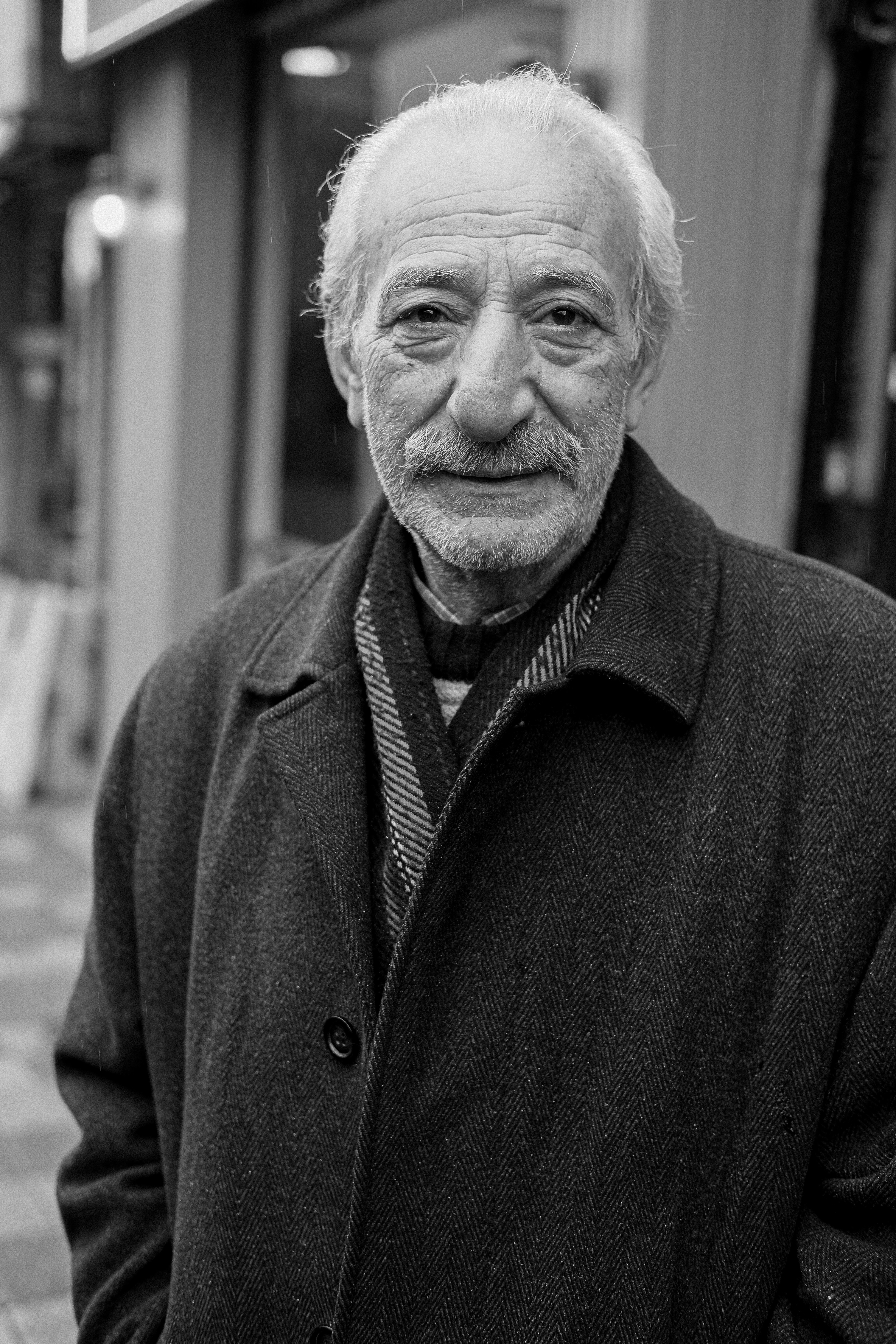 a black and white photo of a man in a coat