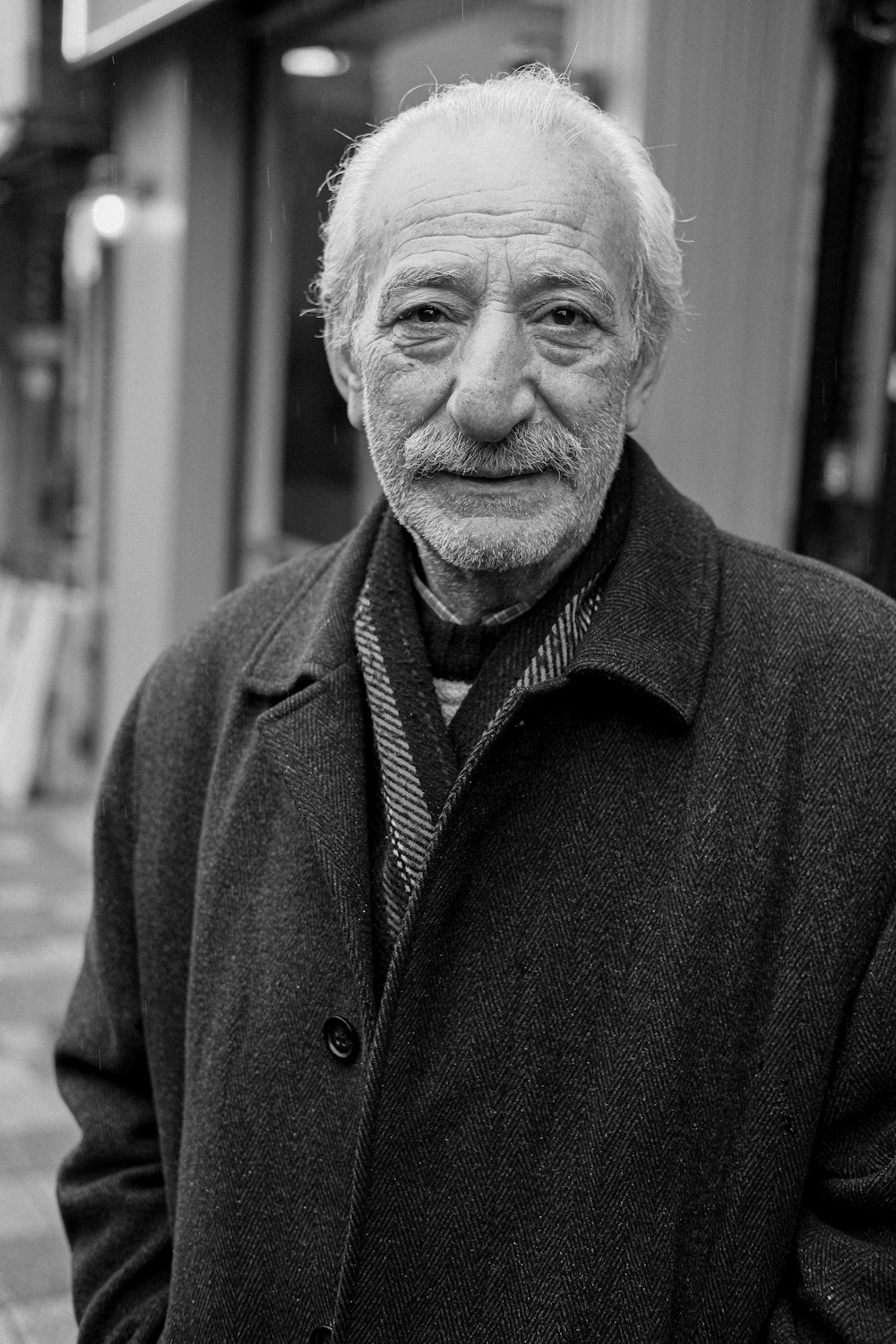 a black and white photo of a man in a coat