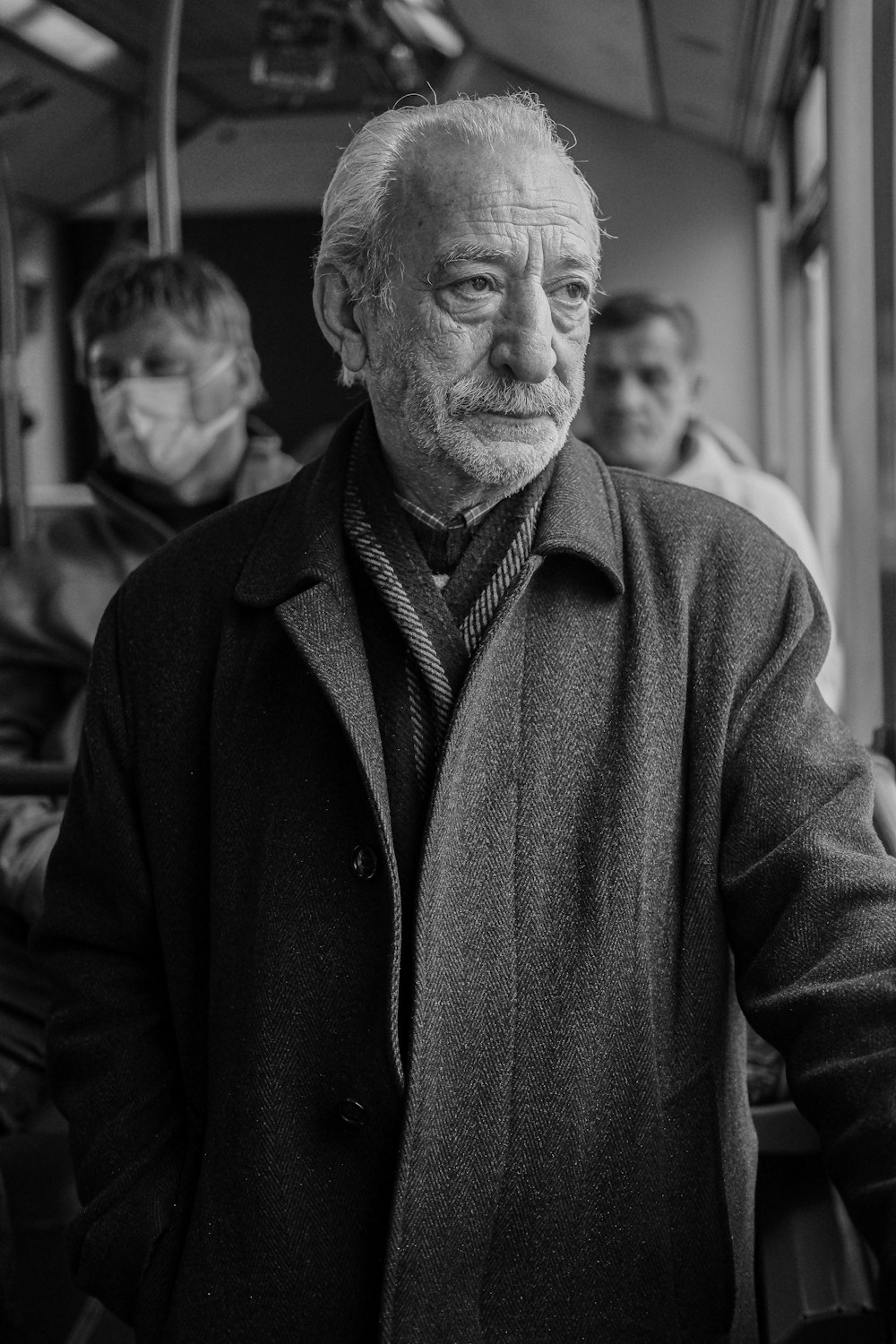 a black and white photo of a man in a coat