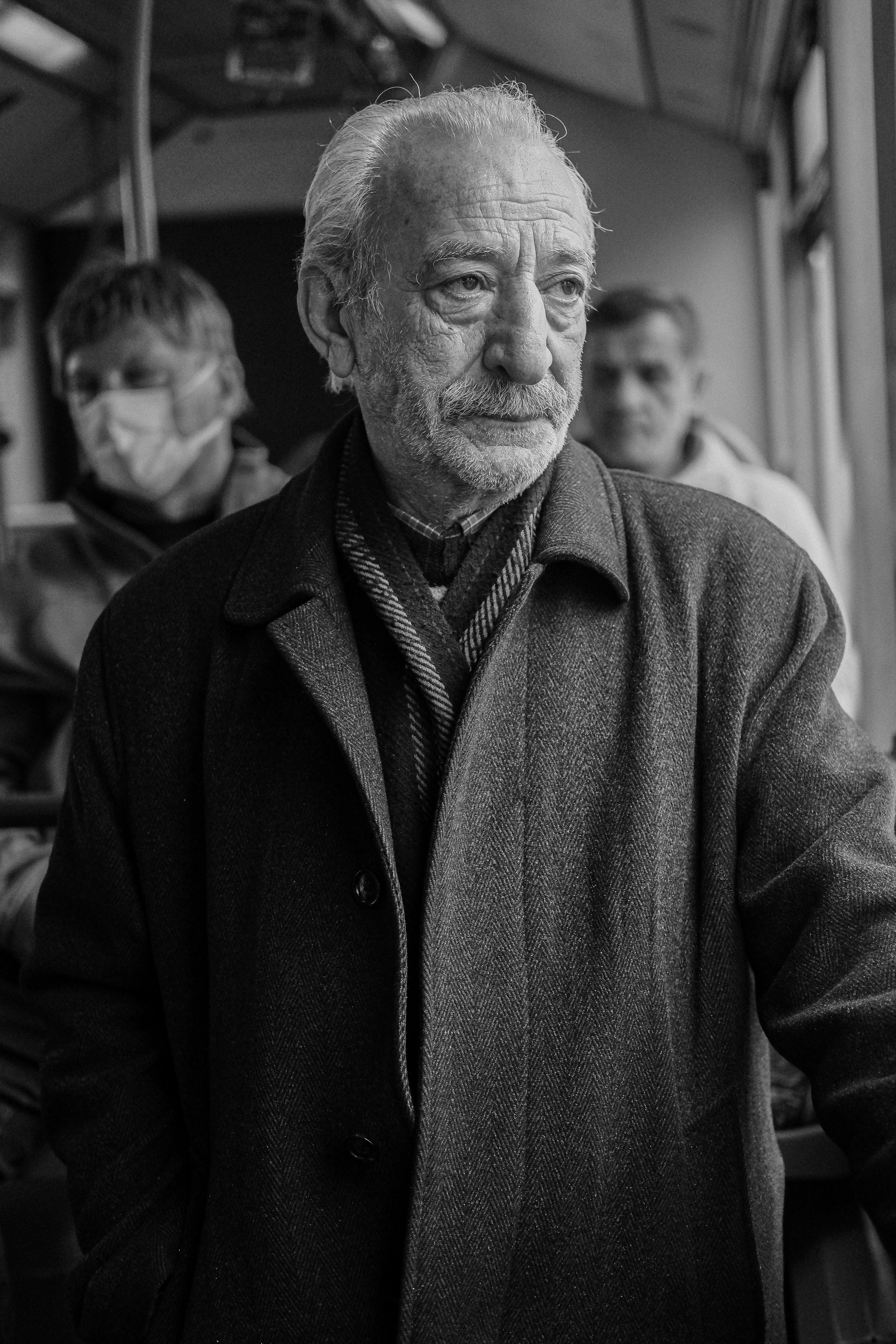 a black and white photo of a man in a coat