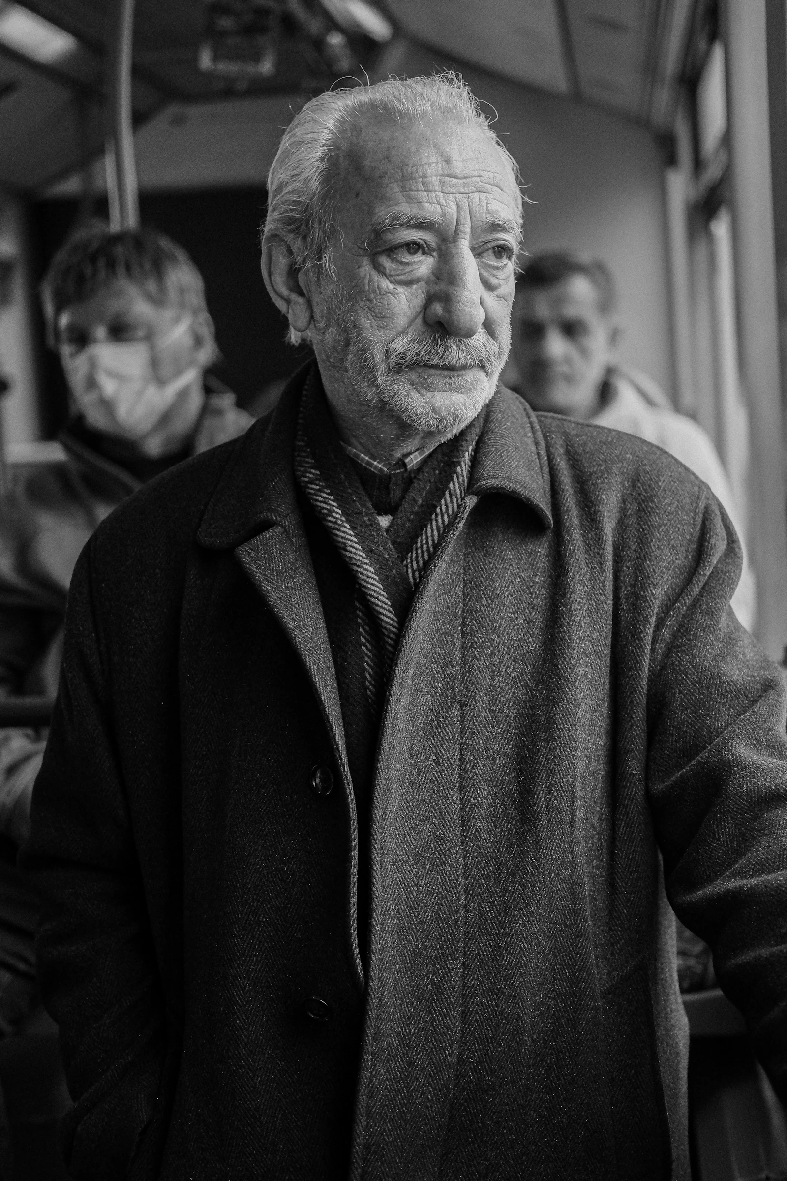 A black and white photo of a man in a coat