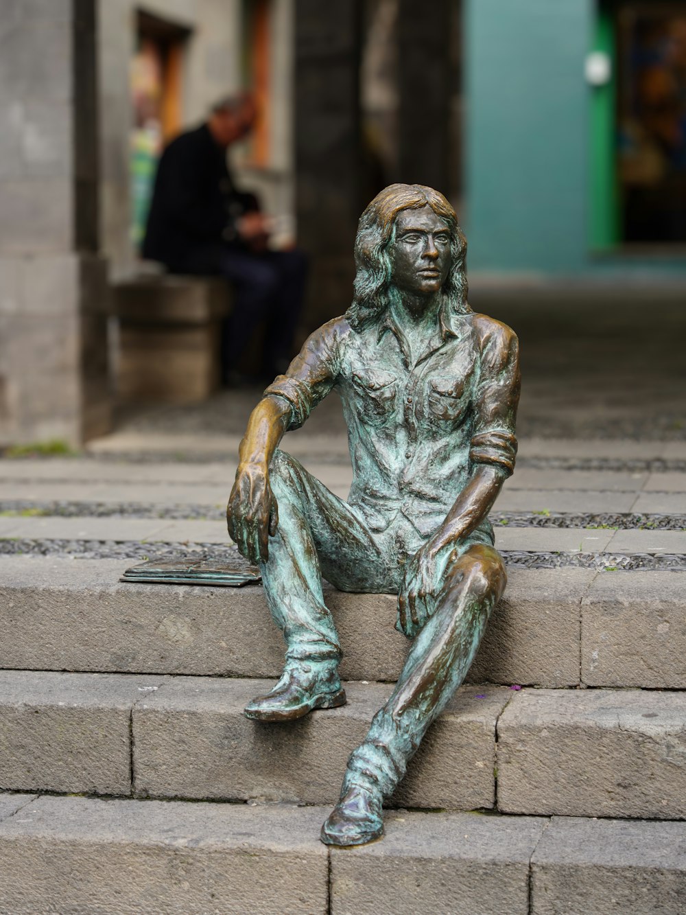 a statue of a man sitting on some steps