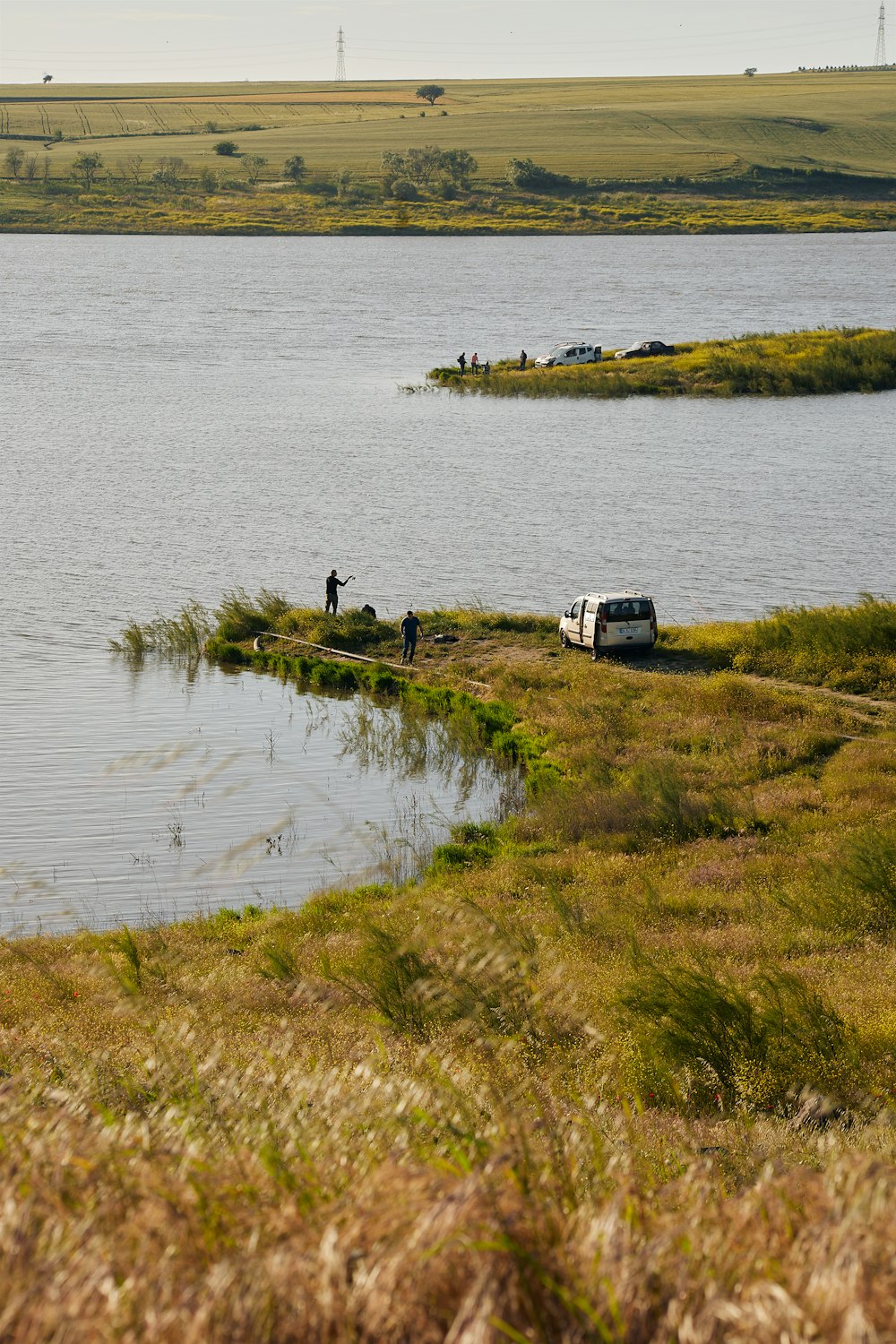 a van is parked on the shore of a lake