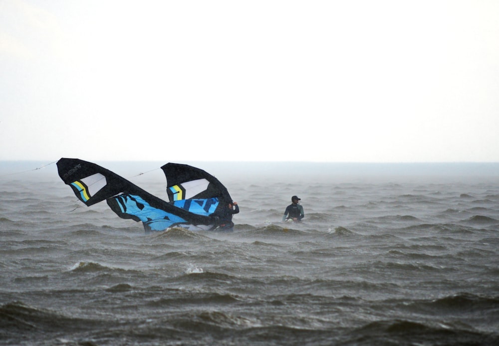 two people in the ocean with a large kite