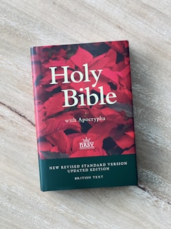 a book on a table with a red flower