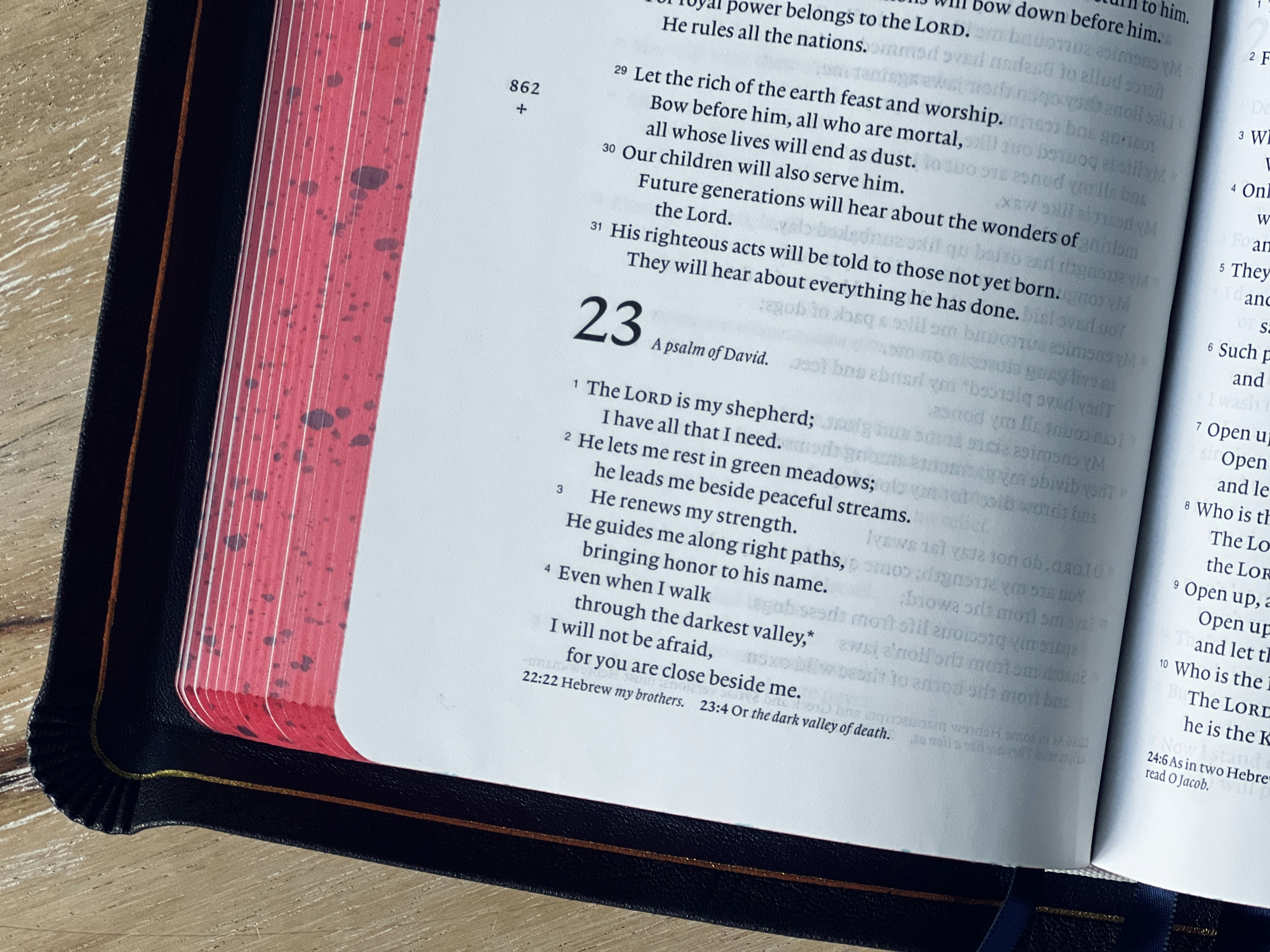 an open book on a wooden table with a pen