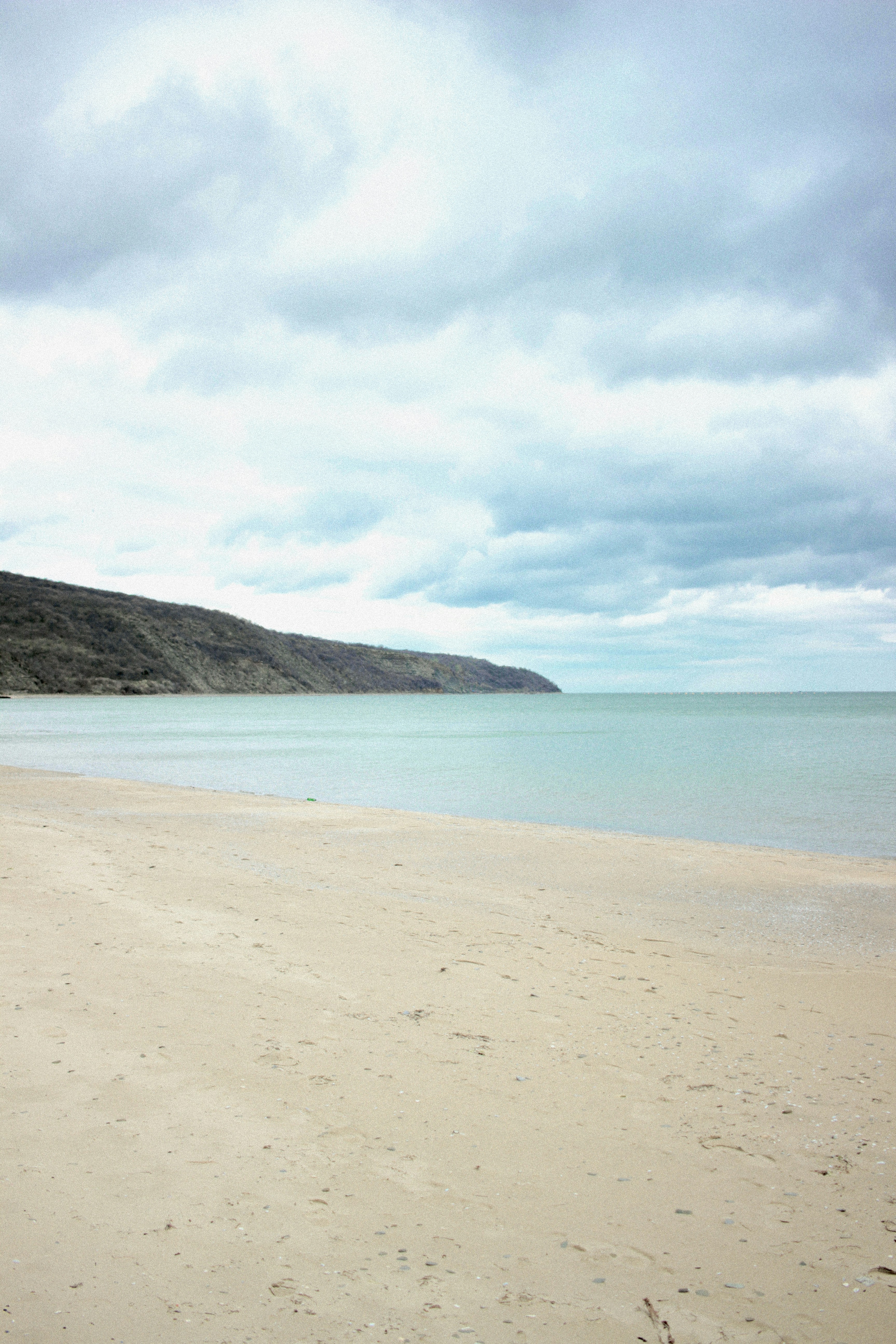 a person walking on a beach with a surfboard