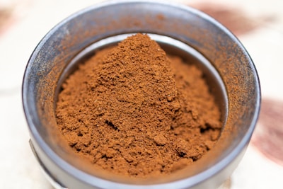 a metal bowl filled with red powder on top of a table