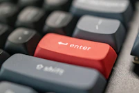 a computer keyboard with a red enter button