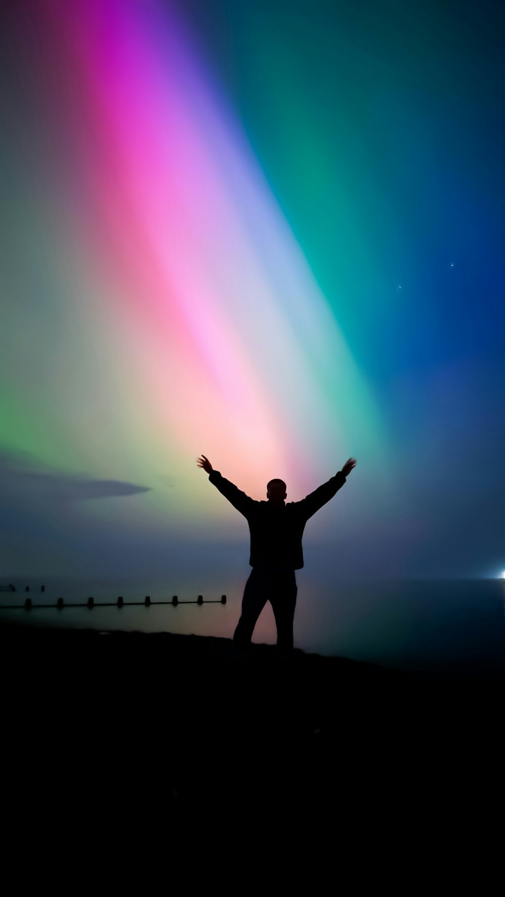 una persona de pie frente a una luz de colores
