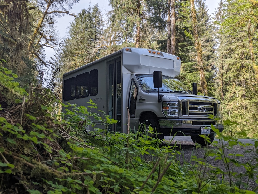 an rv parked in the middle of a forest