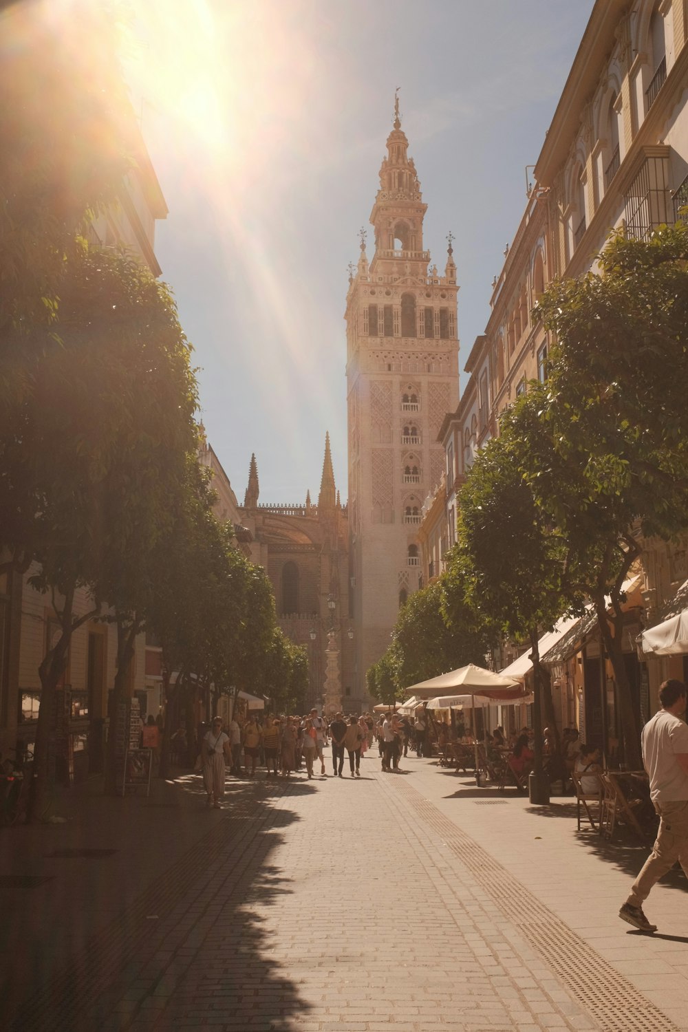 uma rua da cidade com uma torre do relógio ao fundo