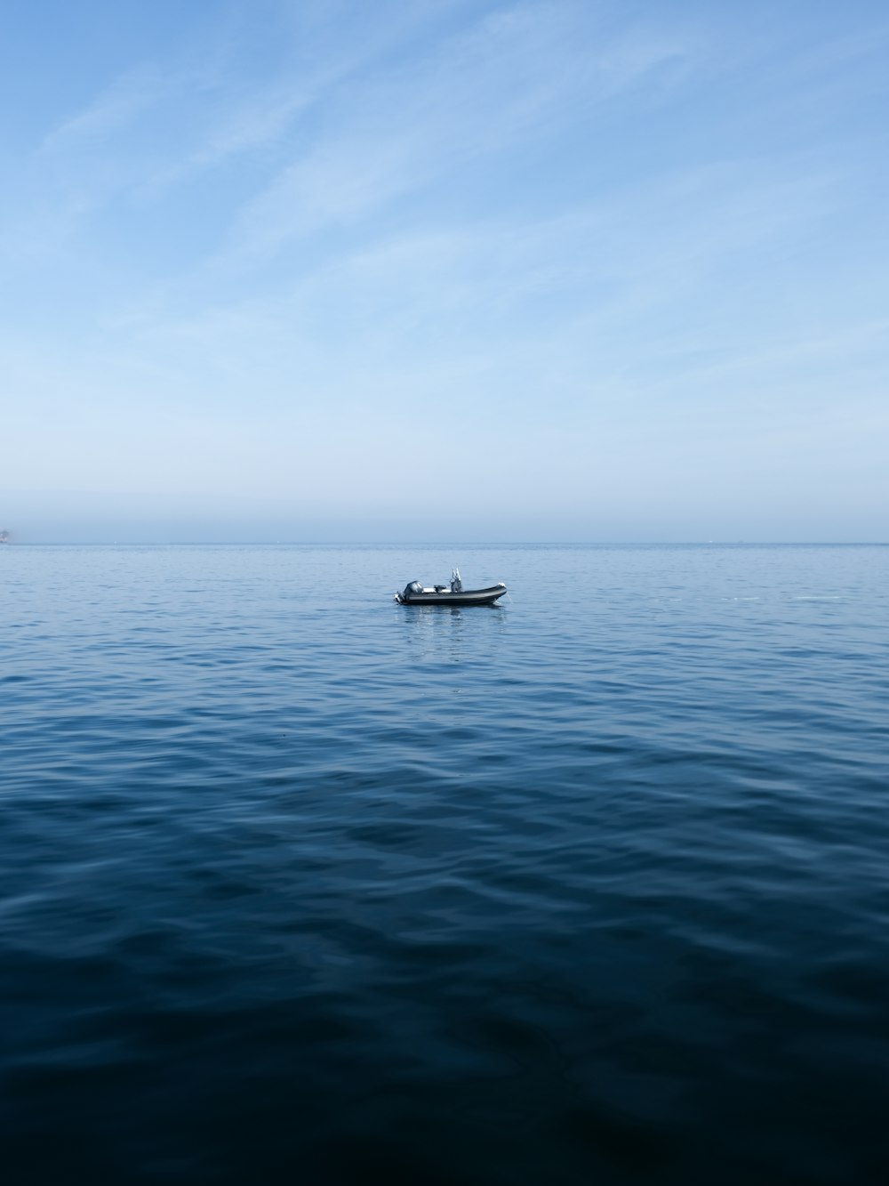 a small boat floating on top of a large body of water