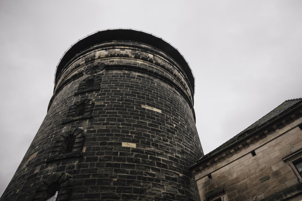 a tall brick tower with a clock on it's side