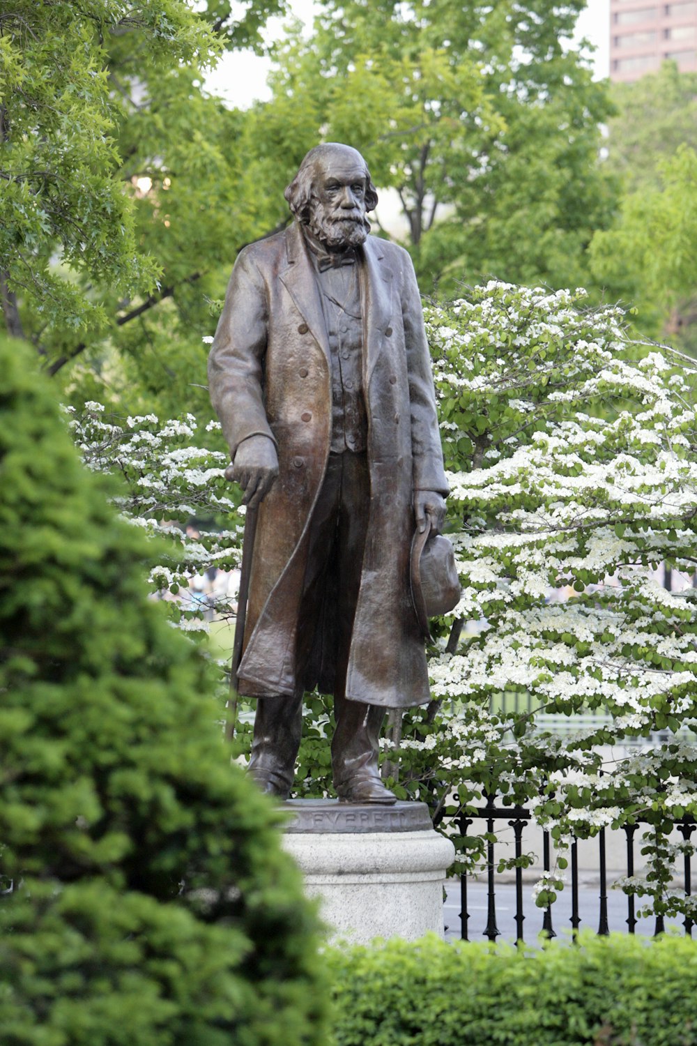 a statue of a man with a cane in a park