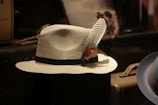 a white hat with a feather on top of it