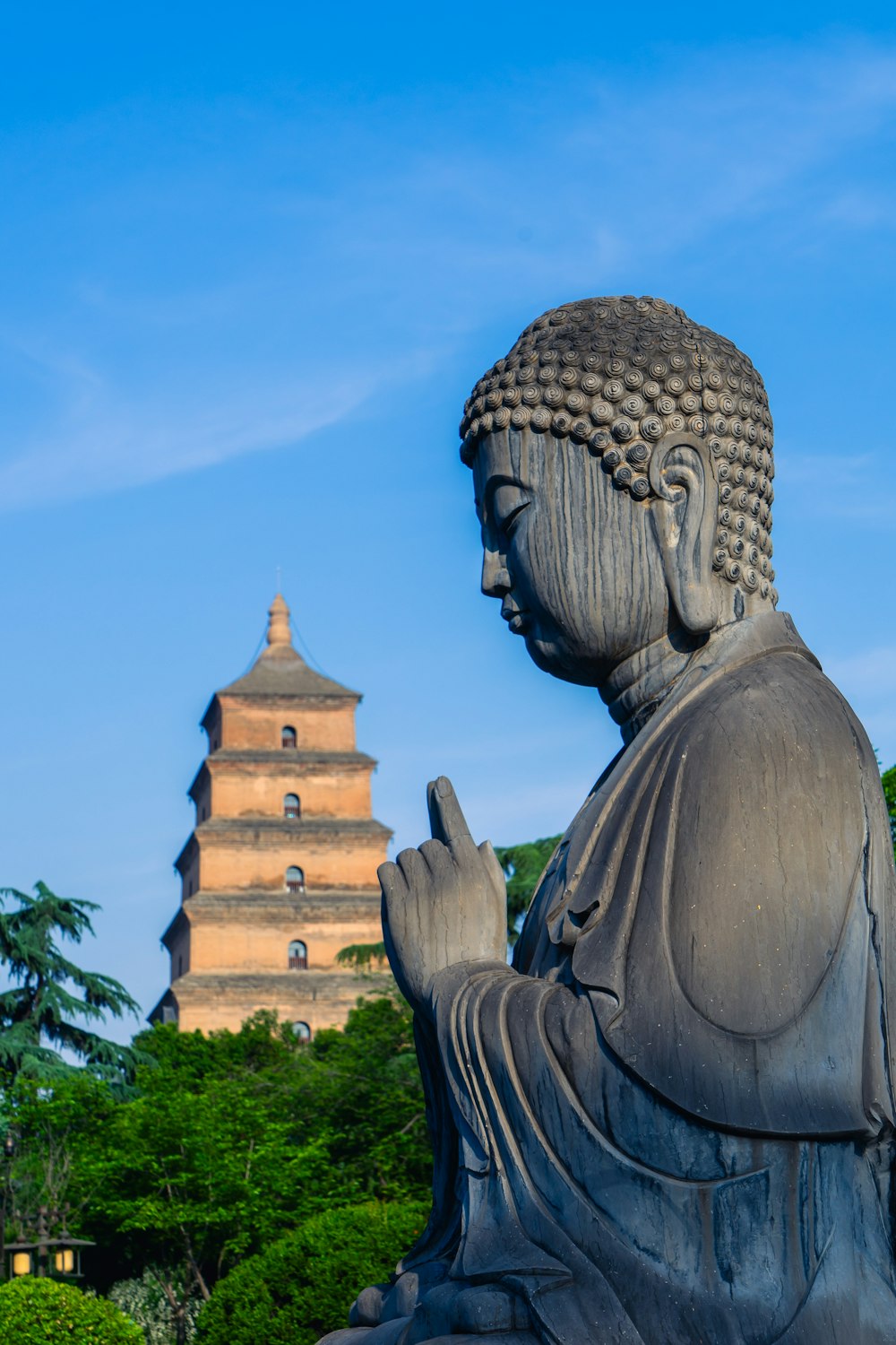 a statue of a buddha in front of a pagoda