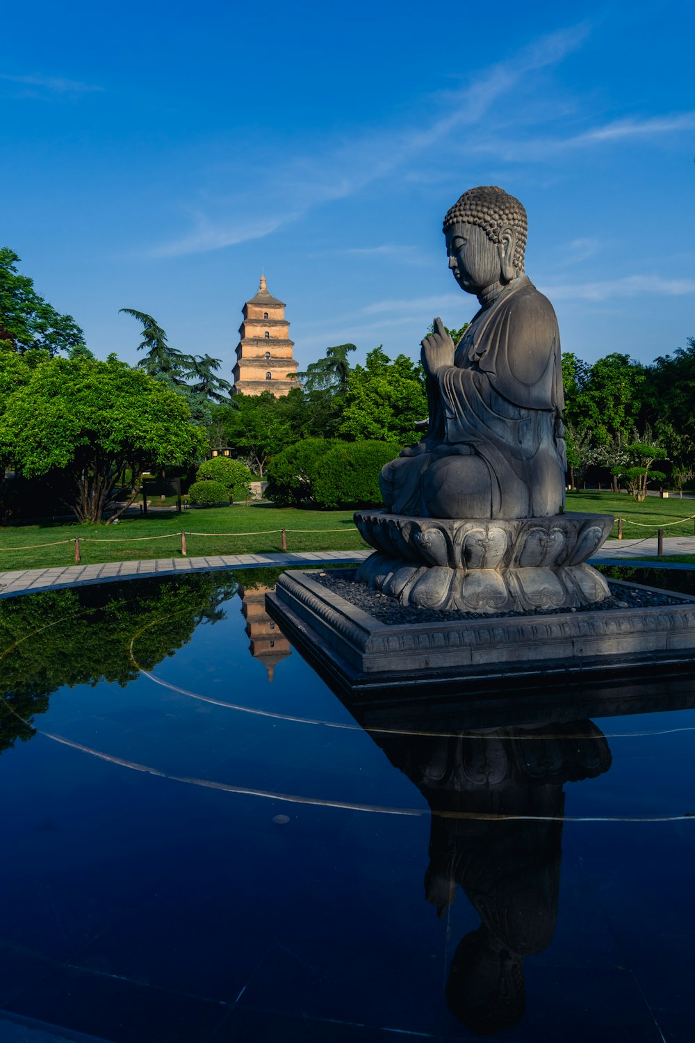 a buddha statue sitting on top of a body of water