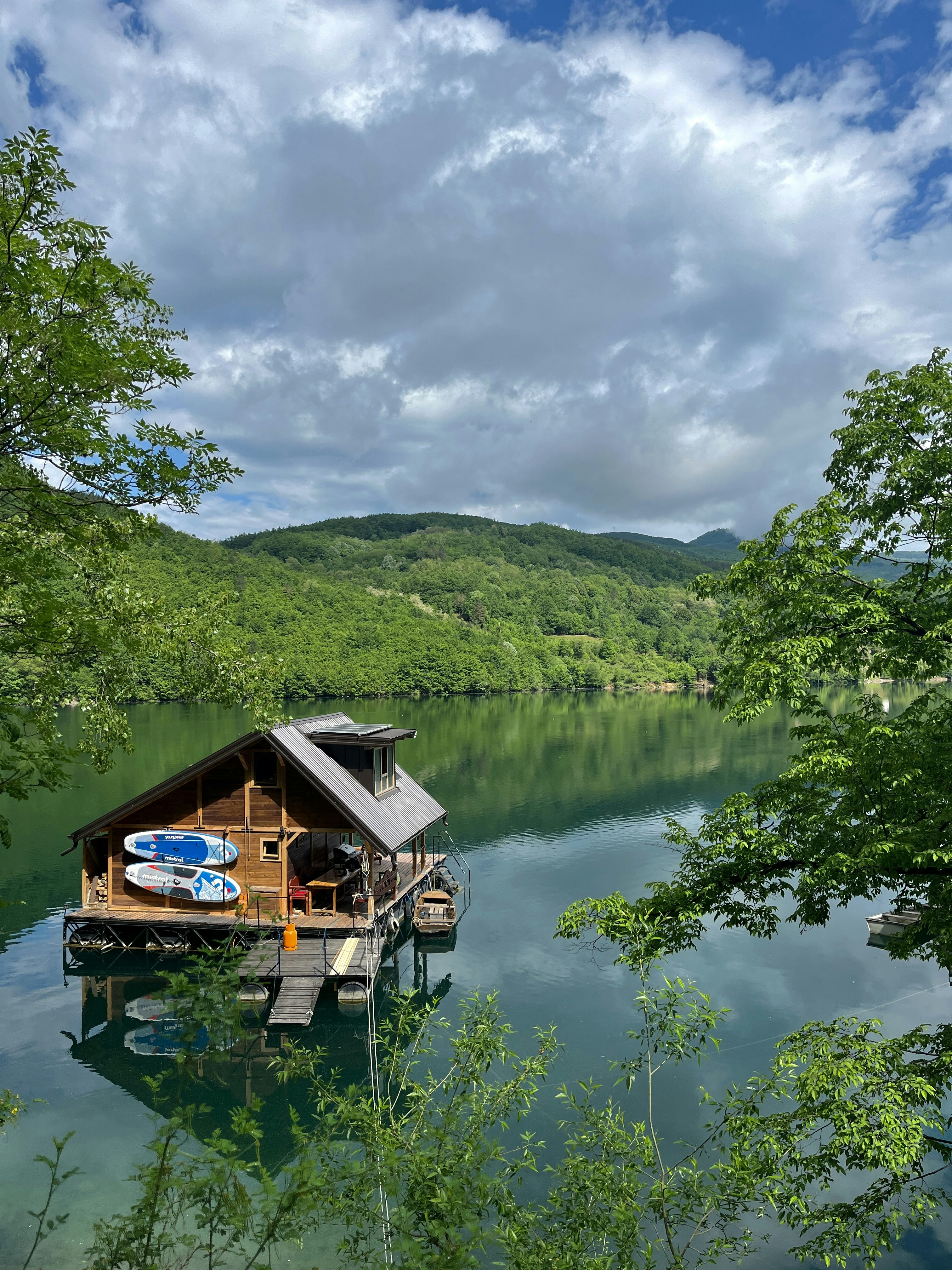 a house on a lake surrounded by trees