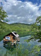 a house on a lake surrounded by trees