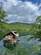 a house on a lake surrounded by trees