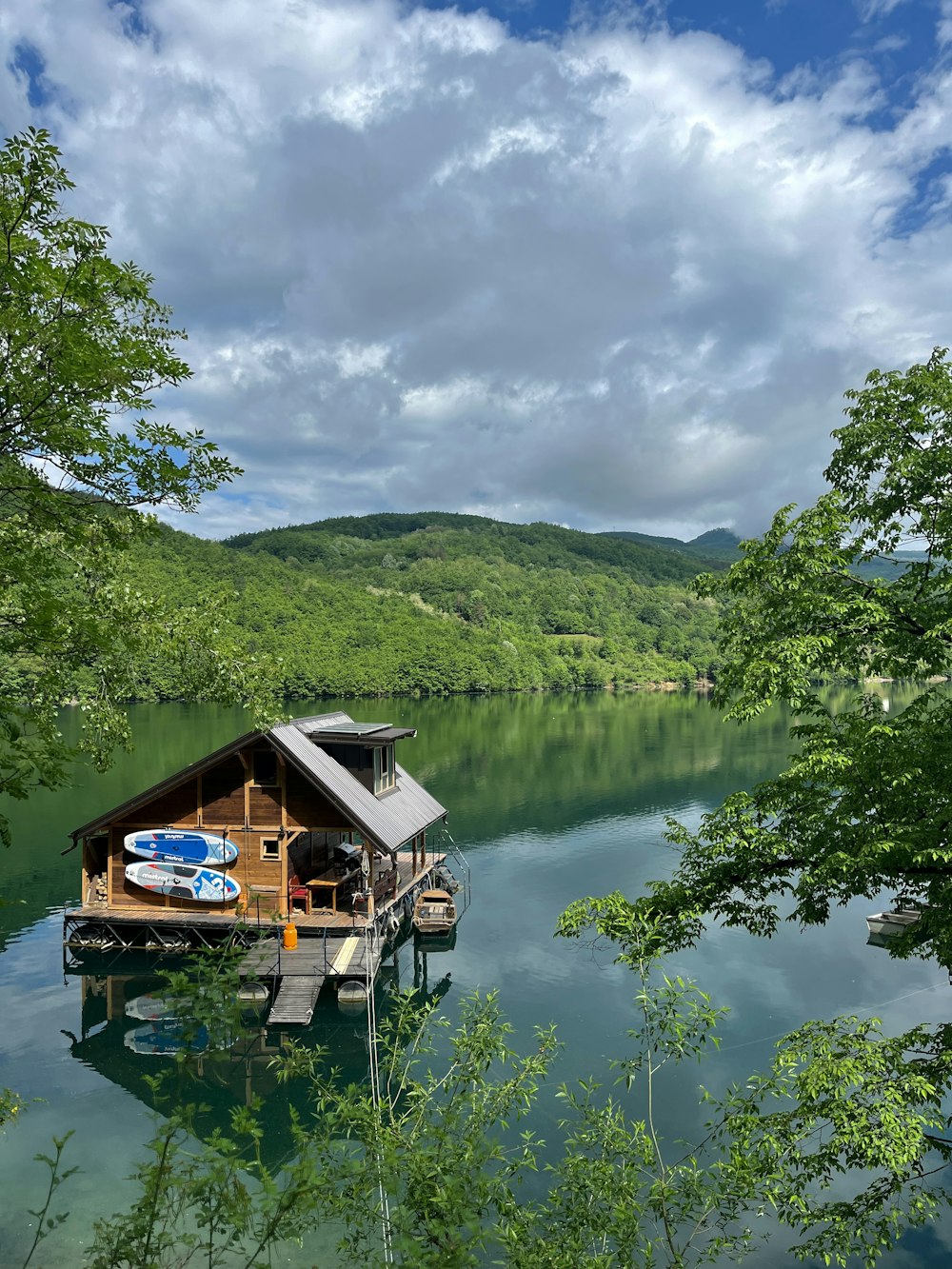 a house on a lake surrounded by trees