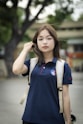 a woman in a blue shirt is holding a skateboard