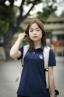 a woman in a blue shirt is holding a skateboard