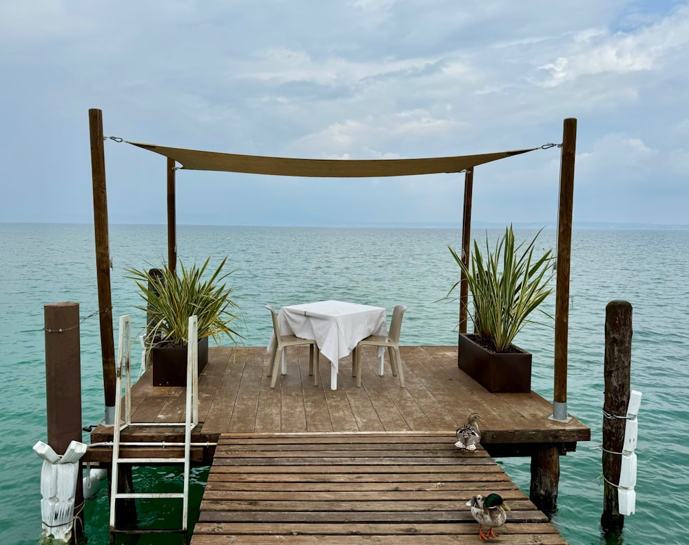 a wooden dock with a table and chairs on it