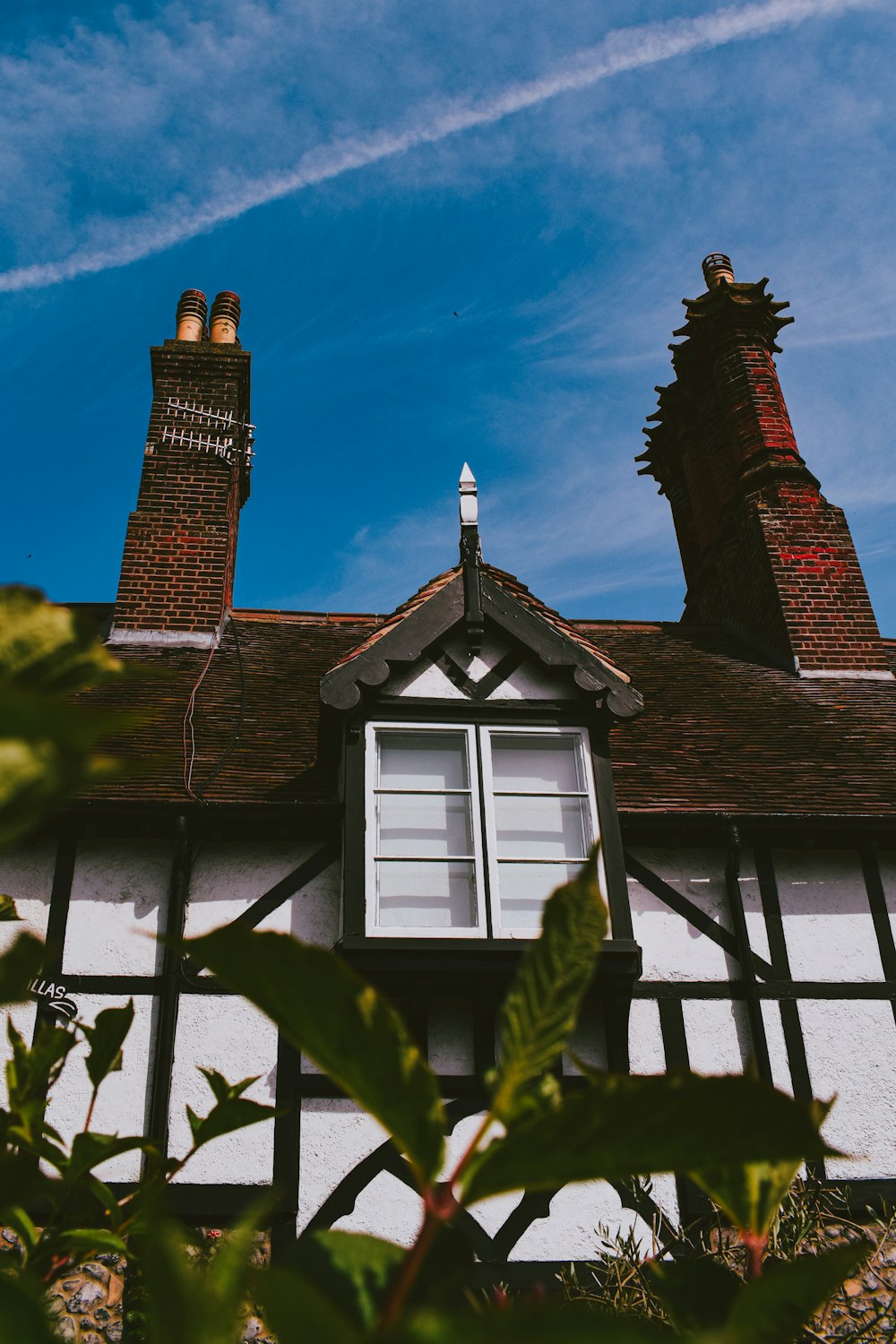 a white house with a black roof and two chimneys